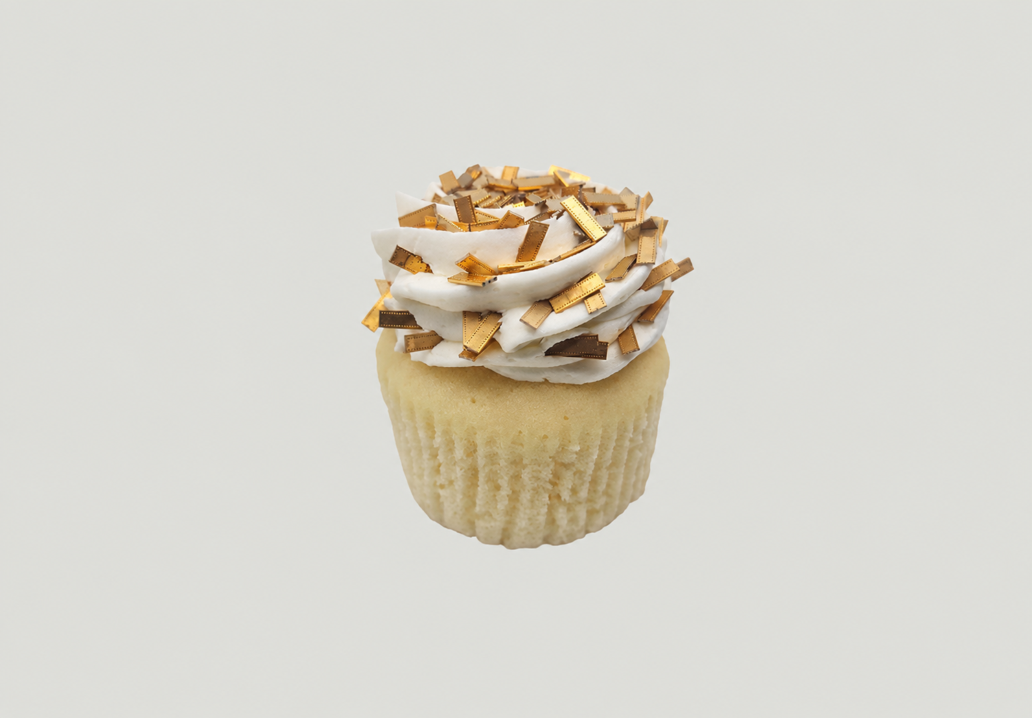 A vanilla cupcake with white frosting, topped with filter sprinkles.